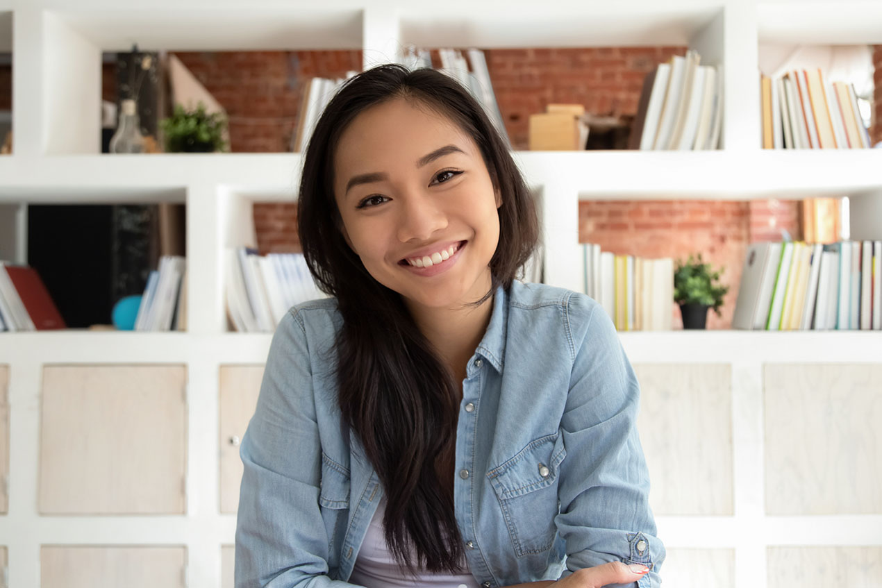 Smiling asian young woman looking at webcam making video call happy marketing intern for small business